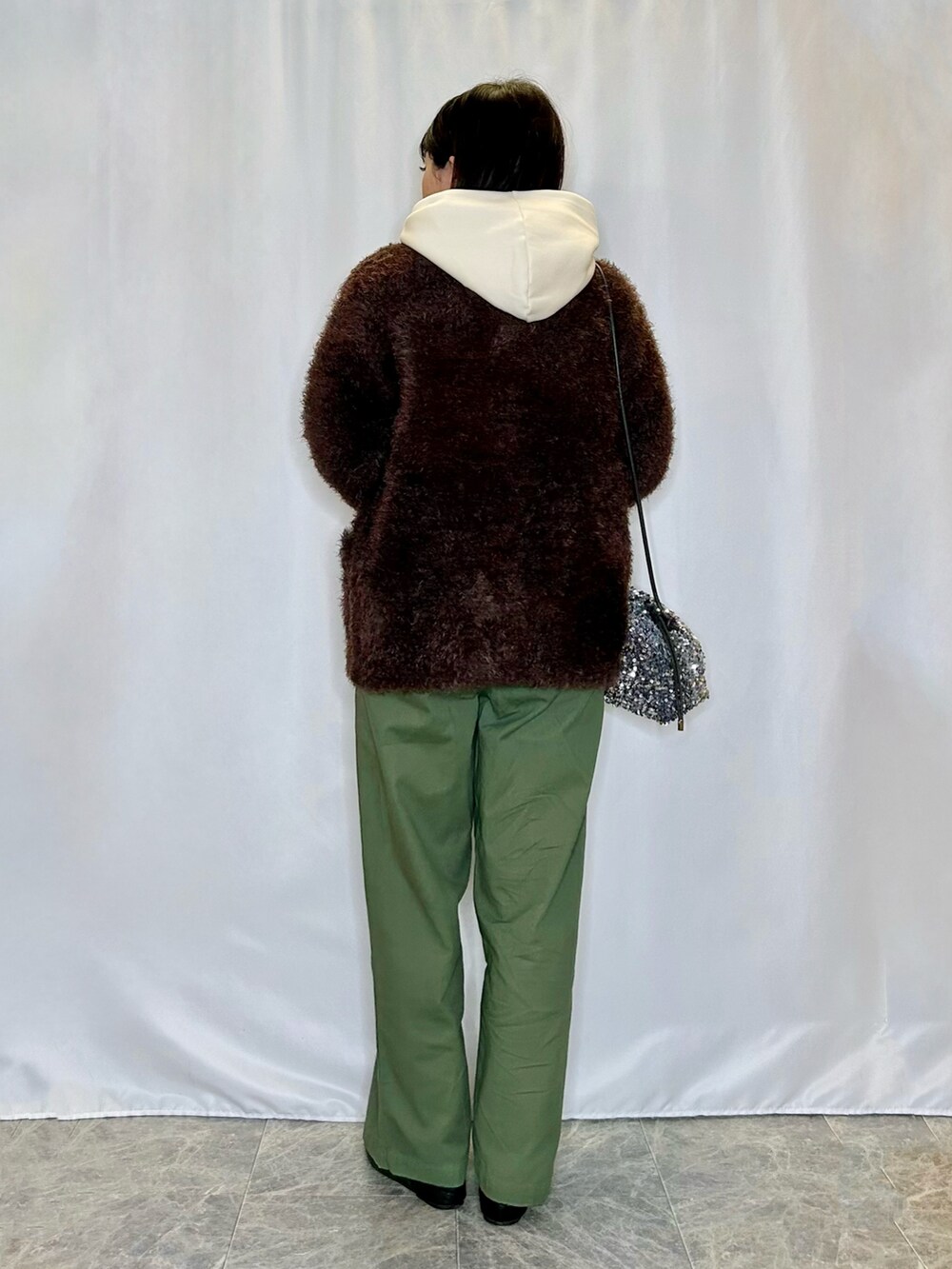 ブラウン系のカーディガン/ボレロ、ホワイト系のスウェット、ブラック系のパンプスを着用したレディースの冬コーディネートの3枚目の写真