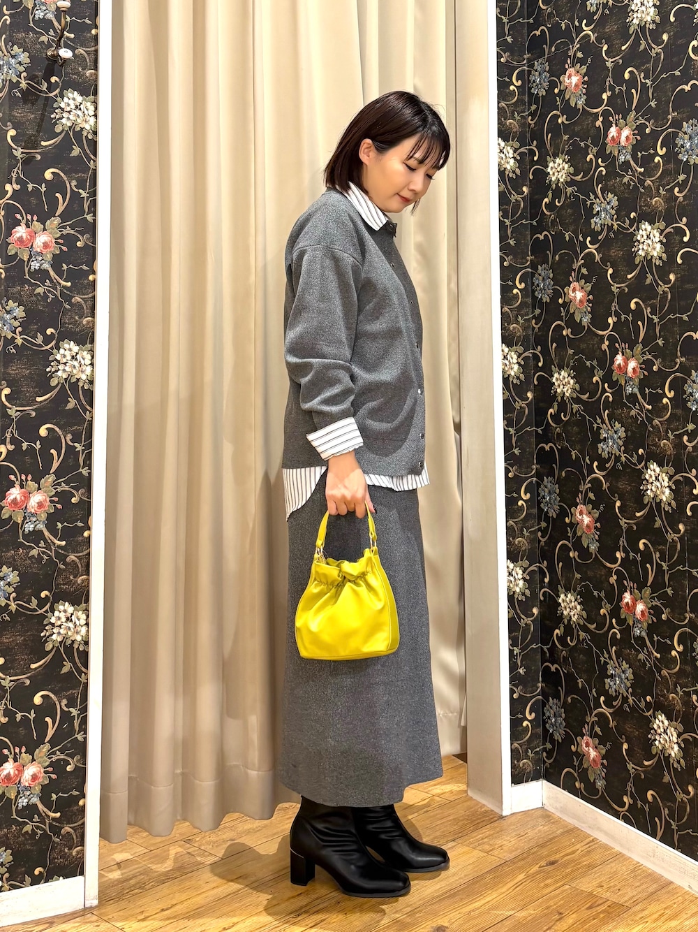 グレー系のカーディガン/ボレロ、ホワイト系のシャツ/ブラウス、グレー系のスカートを着用したレディースの秋コーディネートの2枚目の写真