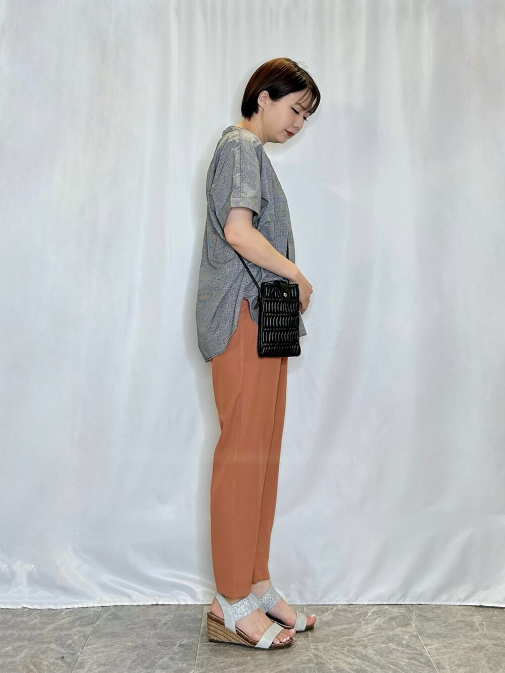 シルバー系のサンダル、オレンジ系のその他パンツ、ブラック系のシャツ/ブラウスを着用したレディースの春コーディネートの2枚目の写真