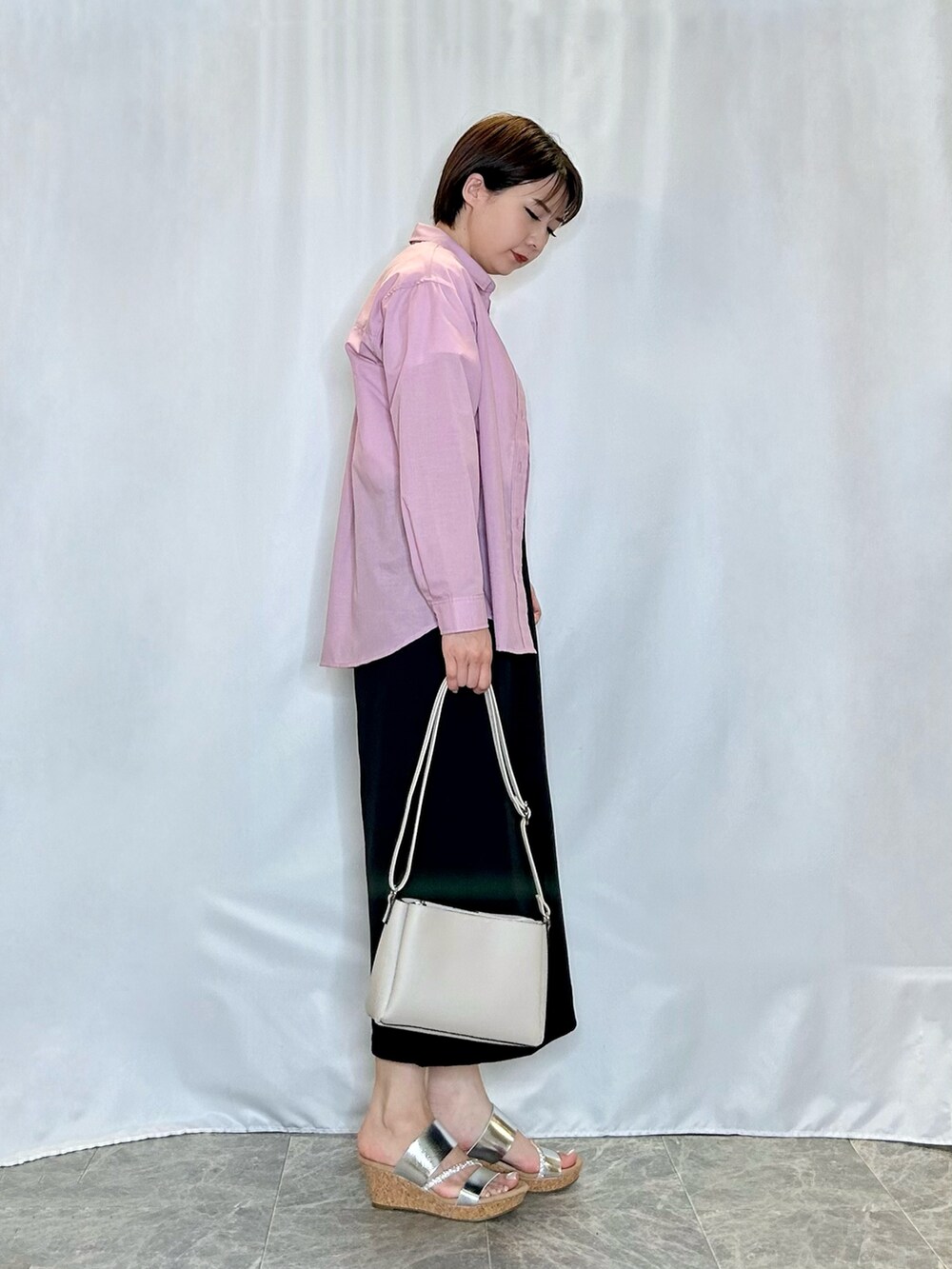 ホワイト系のTシャツ/カットソー、ブラック系のスカート、シルバー系のサンダルを着用したレディースの春コーディネートの2枚目の写真