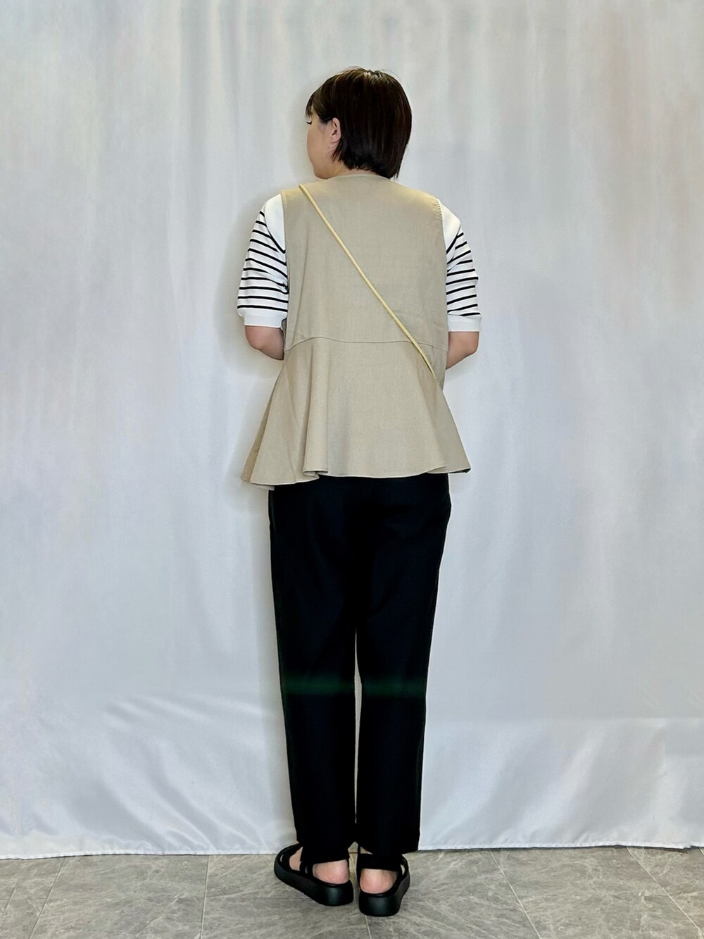 ブラック系のその他パンツ、ブラック系のサンダル、イエロー系のショルダーバッグを着用したレディースの春コーディネートの3枚目の写真