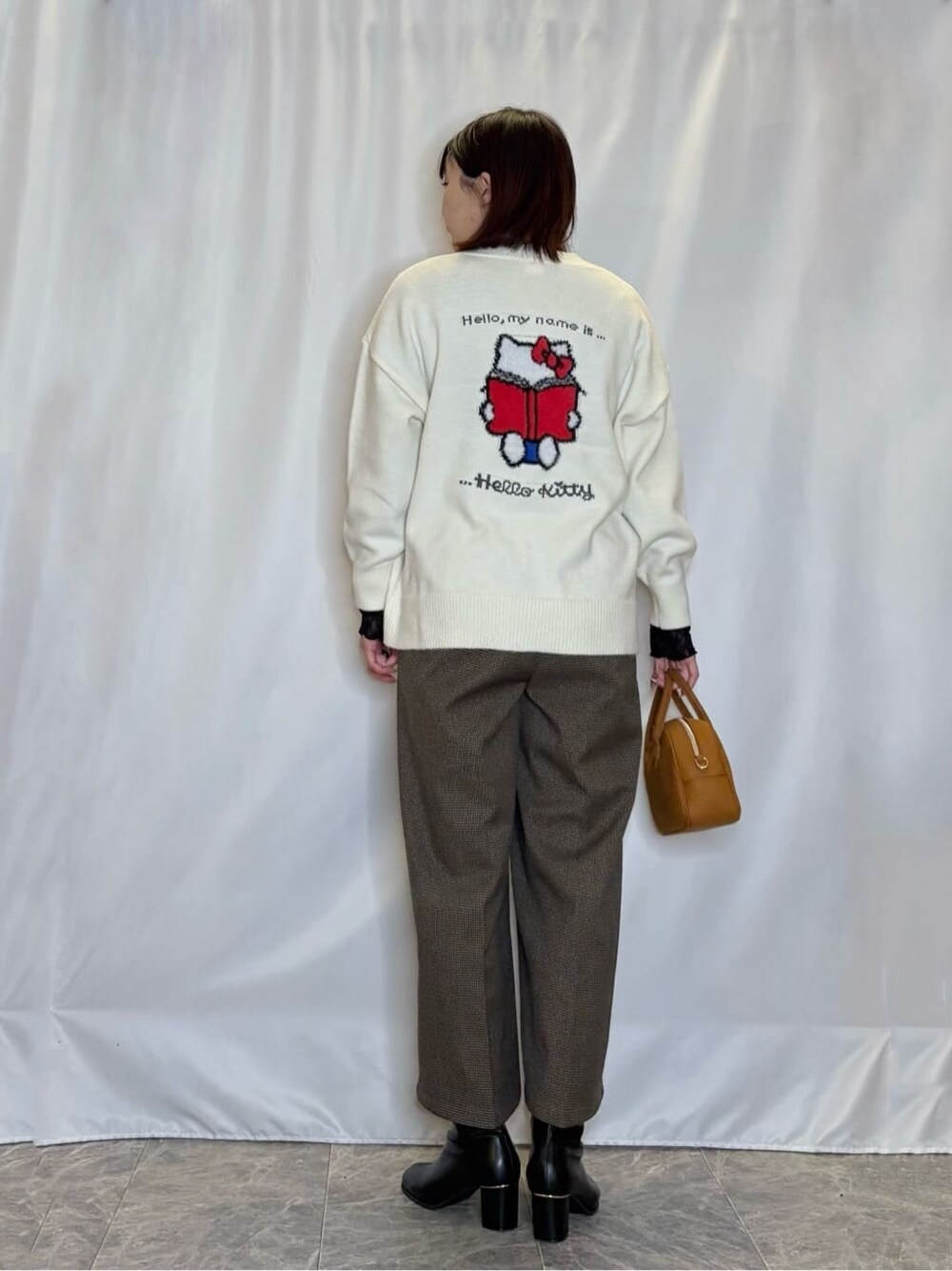 ホワイト系のカーディガン/ボレロ、ブラック系のTシャツ/カットソー、ベージュ系のその他パンツを着用したレディースの冬コーディネートの3枚目の写真