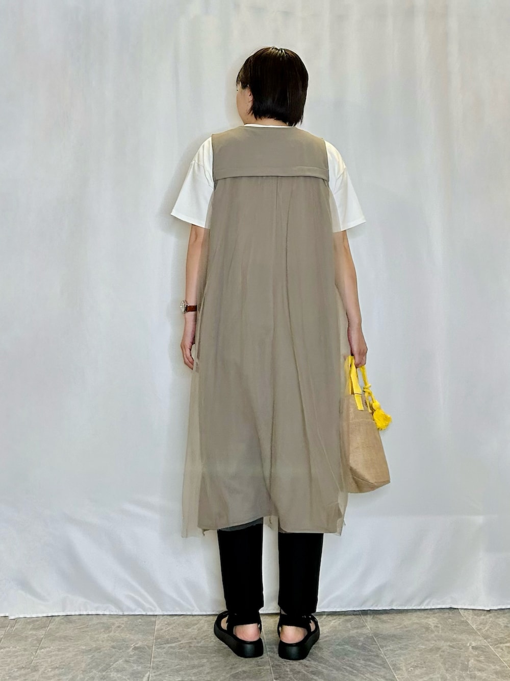 ホワイト系のTシャツ/カットソー、ブラウン系のベスト、ブラック系のその他パンツを着用したレディースの春コーディネートの3枚目の写真