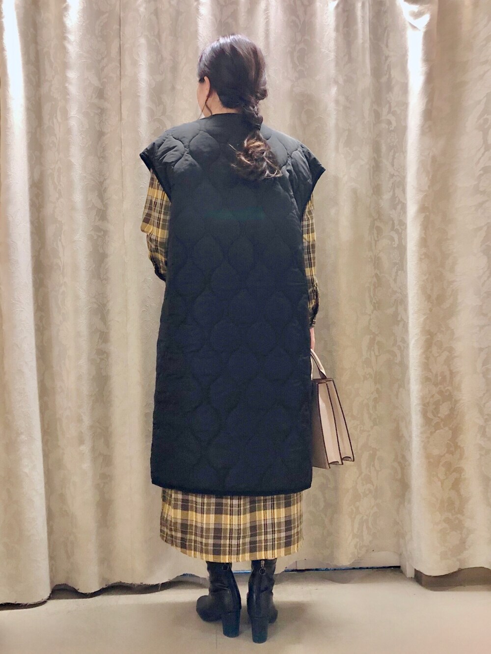 グレー系のショルダーバッグ、ブラック系のブーツ、イエロー系のワンピースを着用したレディースの秋コーディネートの3枚目の写真