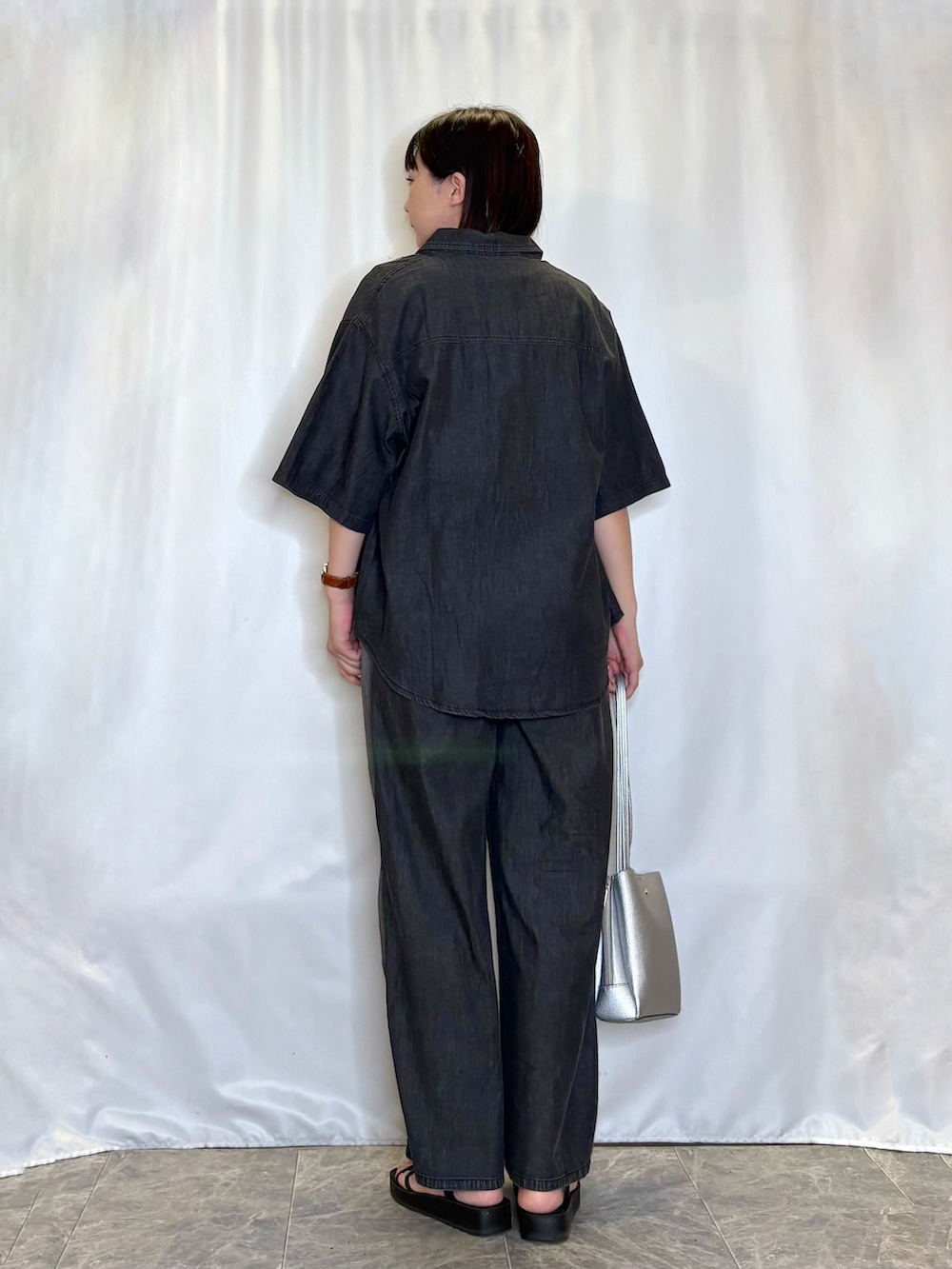 ブラック系のシャツ/ブラウス、ホワイト系のニット/セーター、グレー系のデニムパンツを着用したレディースの夏コーディネートの3枚目の写真