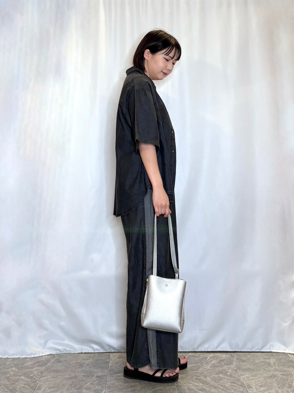 ブラック系のシャツ/ブラウス、ホワイト系のニット/セーター、グレー系のデニムパンツを着用したレディースの夏コーディネートの2枚目の写真