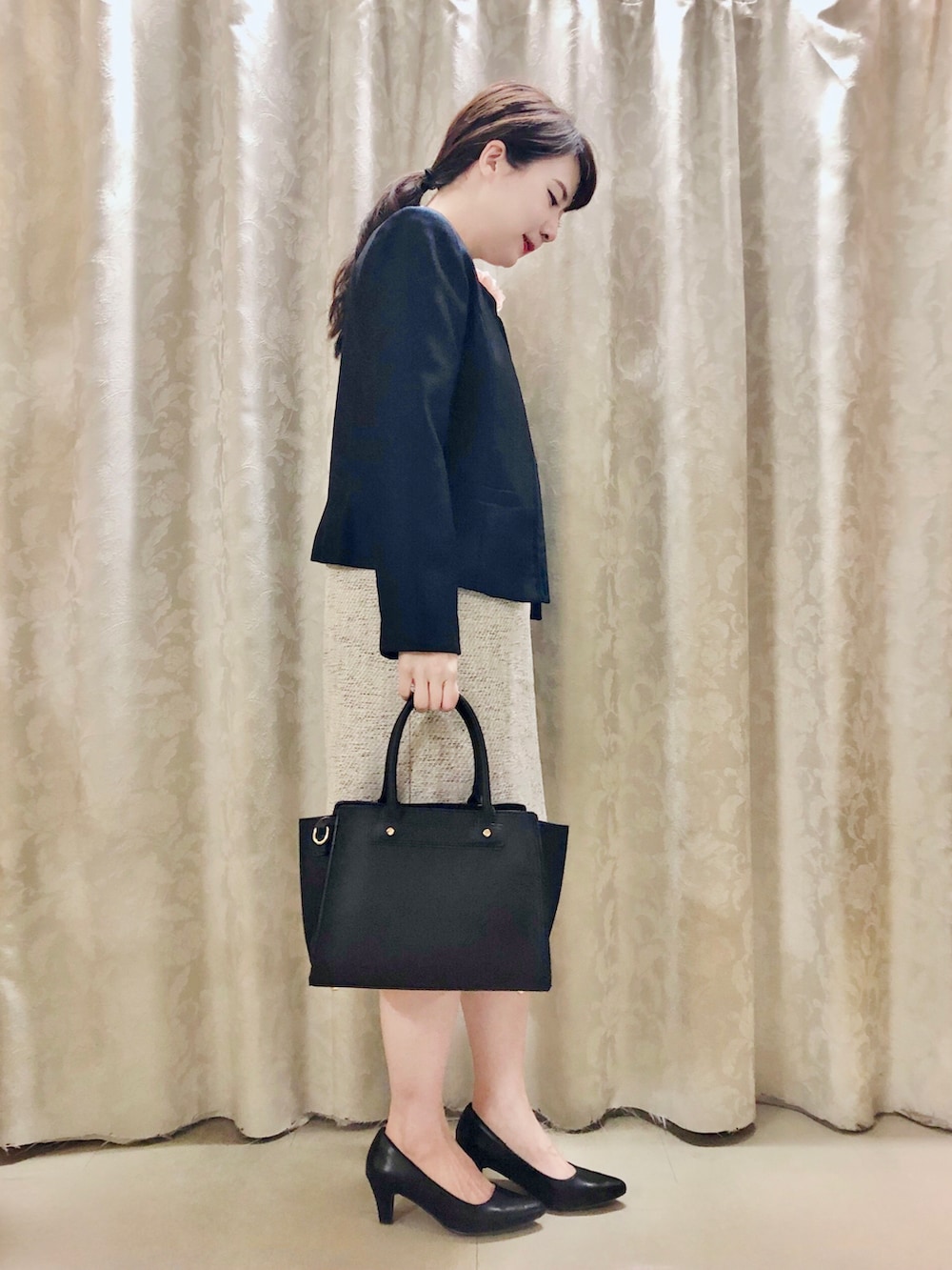 ブルー系のノーカラージャケット、ブラック系のパンプス、グレー系のワンピースを着用したレディースの春コーディネートの2枚目の写真