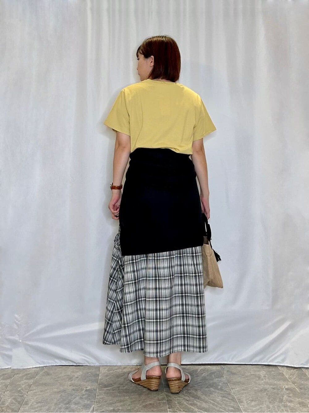 ブラック系のカーディガン/ボレロ、イエロー系のTシャツ/カットソー、ブラック系のスカートを着用したレディースの夏コーディネートの3枚目の写真