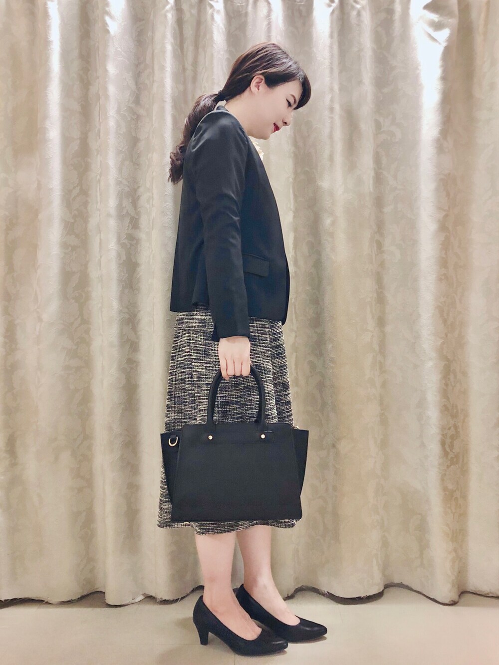 ブラック系のTシャツ/カットソー、ブラック系のスカート、ブラック系のパンプスを着用したレディースの春コーディネートの2枚目の写真