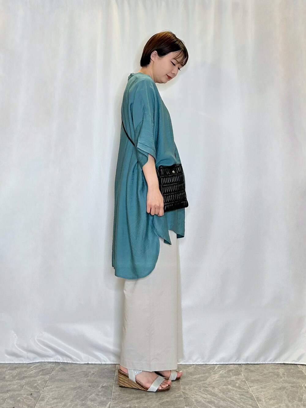 ベージュ系のその他パンツ、シルバー系のサンダル、ブルー系のチュニックを着用したレディースの春コーディネートの2枚目の写真