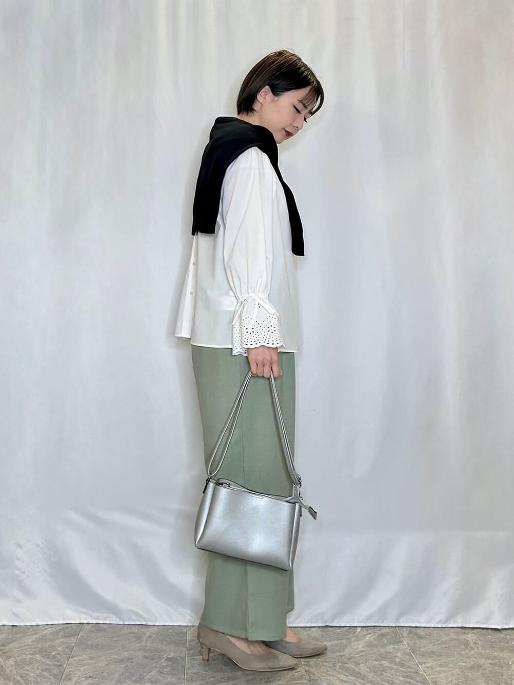ブラック系のカーディガン/ボレロ、ホワイト系のシャツ/ブラウス、グリーン系のその他パンツを着用したレディースの春コーディネートの2枚目の写真