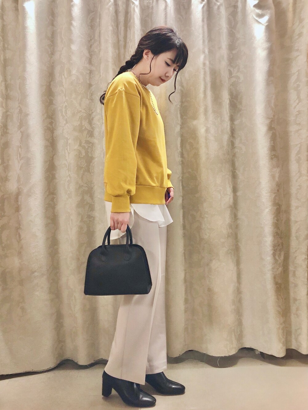 イエロー系のスウェット、ホワイト系のシャツ/ブラウス、ブラック系のブーツを着用したレディースの秋コーディネートの2枚目の写真