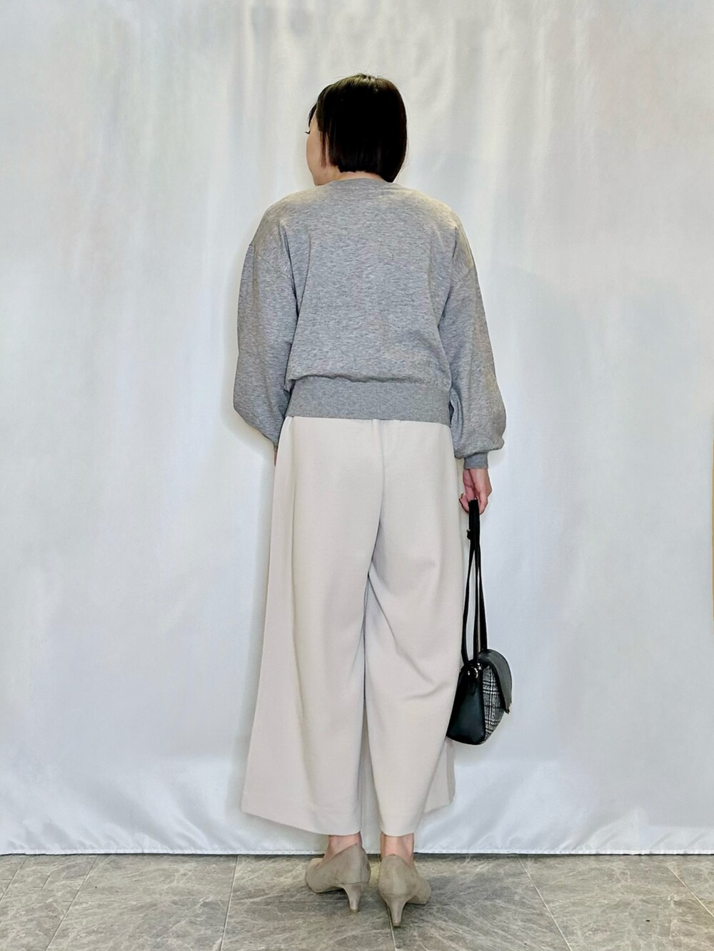 ベージュ系のその他パンツ、ブラック系のショルダーバッグ、ベージュ系のパンプスを着用したレディースの冬コーディネートの3枚目の写真