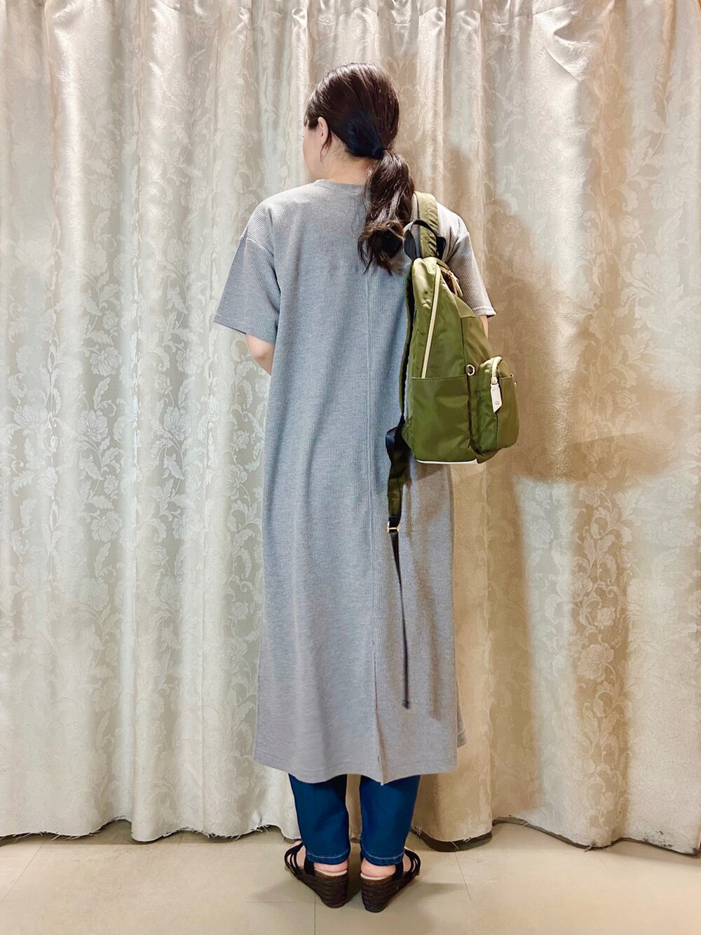 グリーン系のバックパック/リュック、ブラック系のサンダル、ブルー系のデニムパンツを着用したレディースの春コーディネートの3枚目の写真