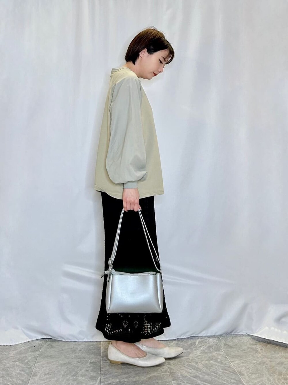 グリーン系のTシャツ/カットソー、ブラック系のスカート、ゴールド系のその他シューズを着用したレディースの春コーディネートの2枚目の写真