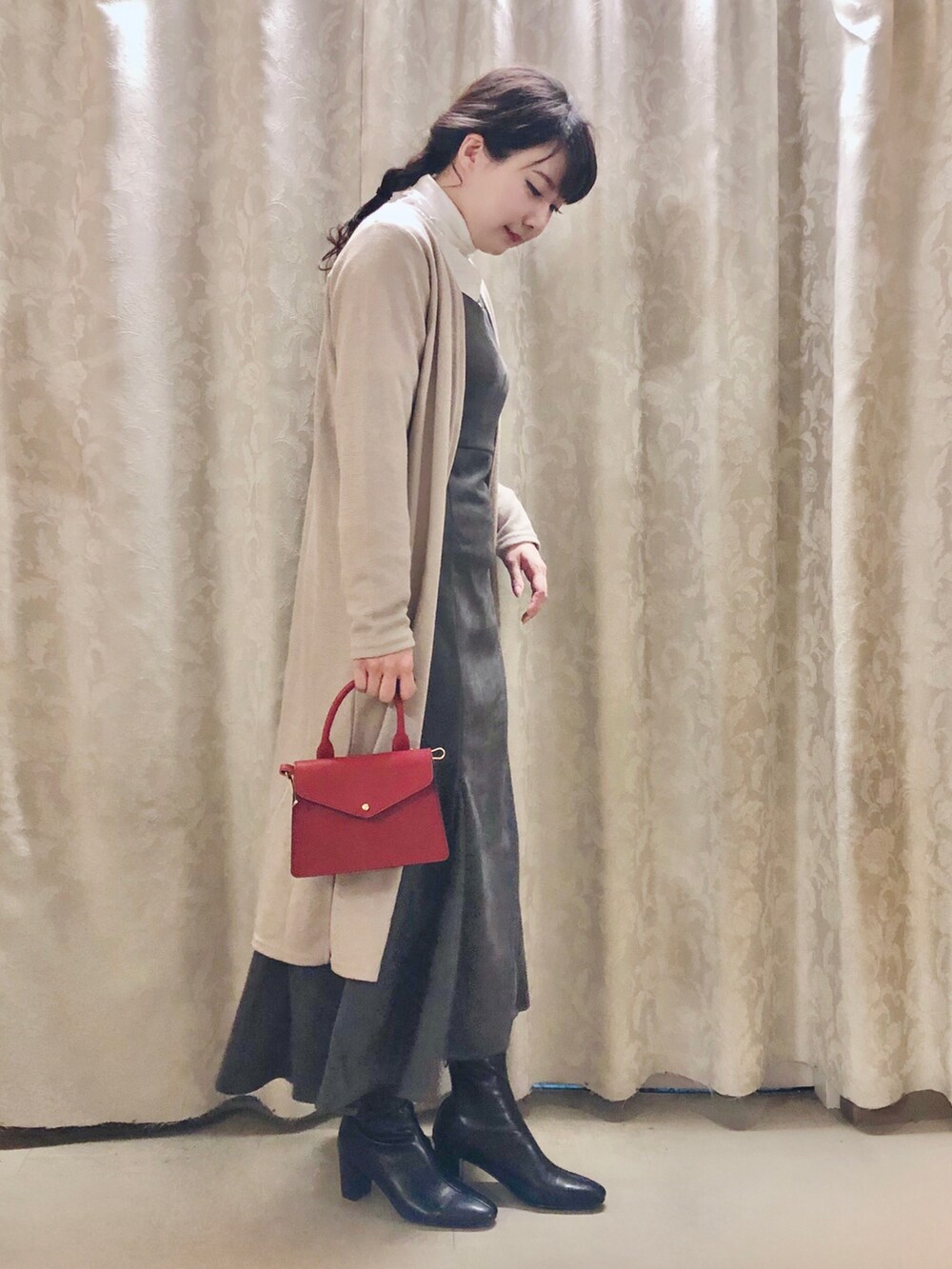 レッド系のショルダーバッグ、ホワイト系のTシャツ/カットソー、ベージュ系のカーディガン/ボレロを着用したレディースの秋コーディネートの2枚目の写真