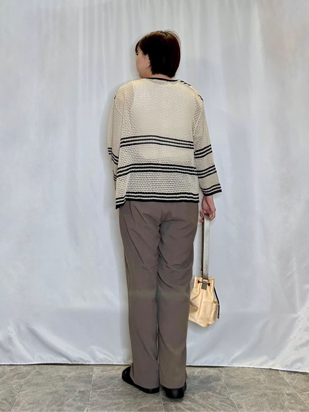 ホワイト系のカーディガン/ボレロ、ホワイト系のタンクトップ、ブラウン系のその他パンツを着用したレディースの春コーディネートの3枚目の写真