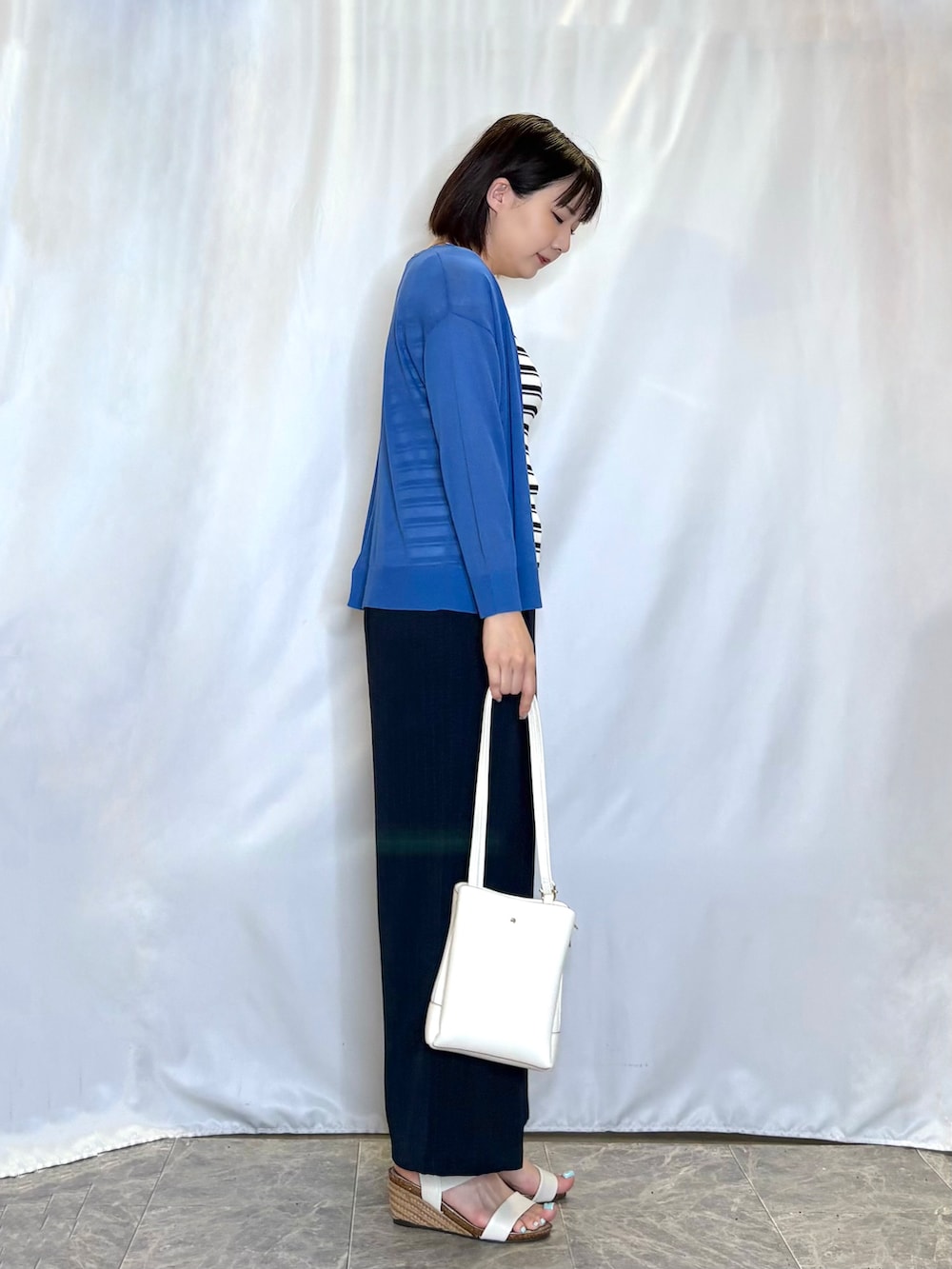 ブルー系のカーディガン/ボレロ、ベージュ系のニット/セーター、ホワイト系のサンダルを着用したレディースの夏コーディネートの3枚目の写真