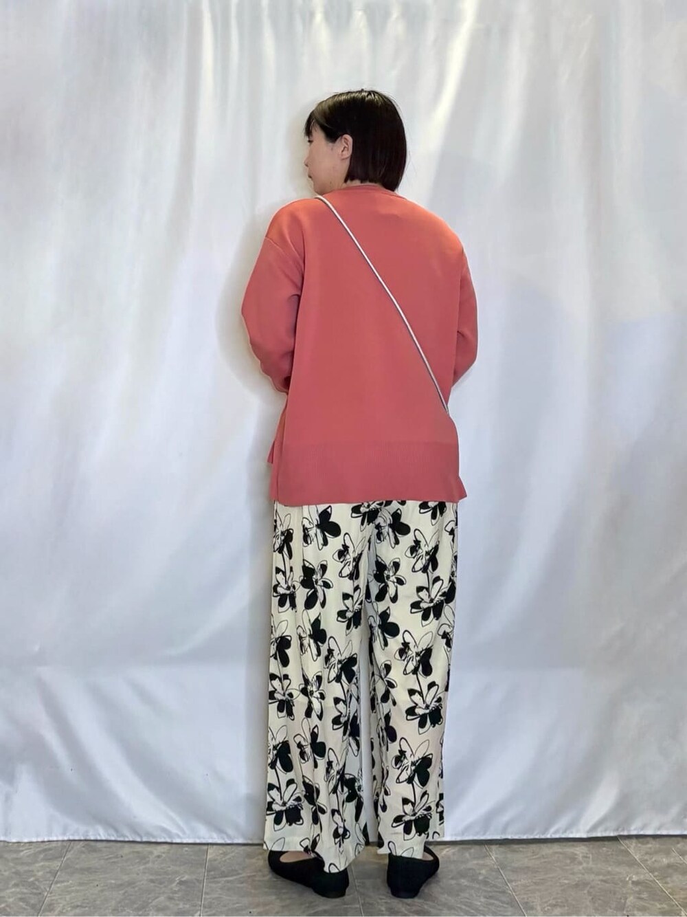 ピンク系のニット/セーター、ベージュ系のその他パンツ、ブラック系のパンプスを着用したレディースの春コーディネートの3枚目の写真