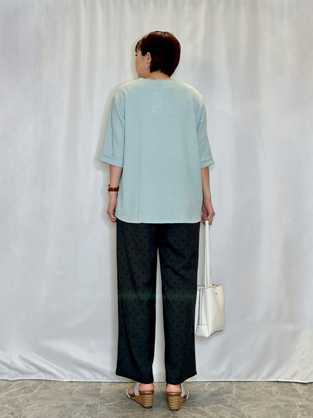 グレー系のその他パンツ、シルバー系のサンダル、ブルー系のTシャツ/カットソーを着用したレディースの春コーディネートの3枚目の写真