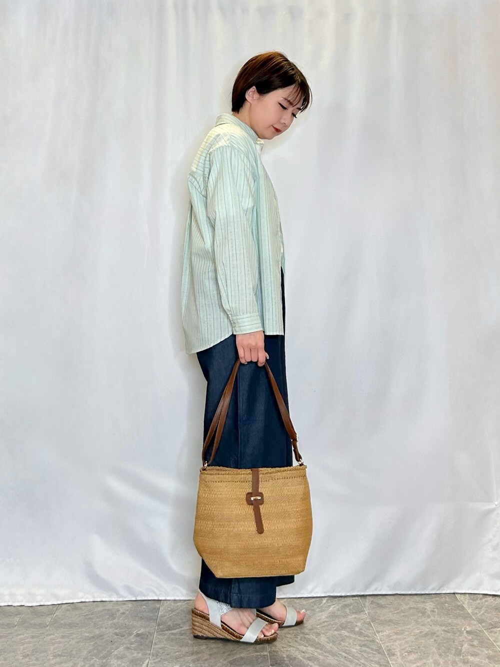 ベージュ系のショルダーバッグ、シルバー系のサンダル、ブルー系のその他パンツを着用したレディースの春コーディネートの2枚目の写真