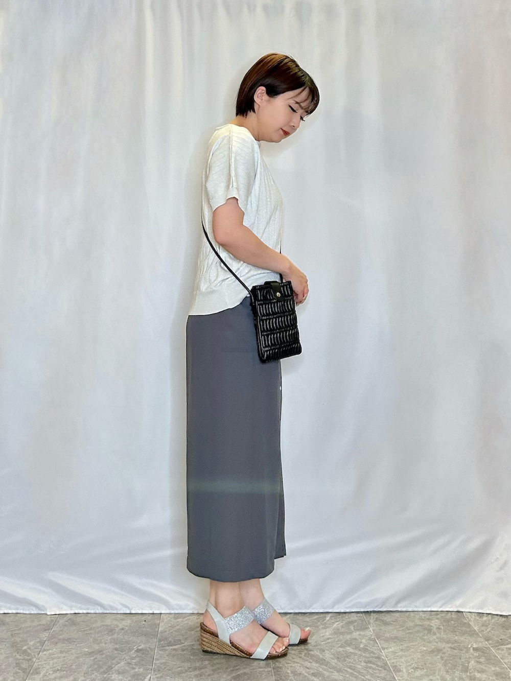 シルバー系のニット/セーター、グレー系のスカート、シルバー系のサンダルを着用したレディースの春コーディネートの2枚目の写真