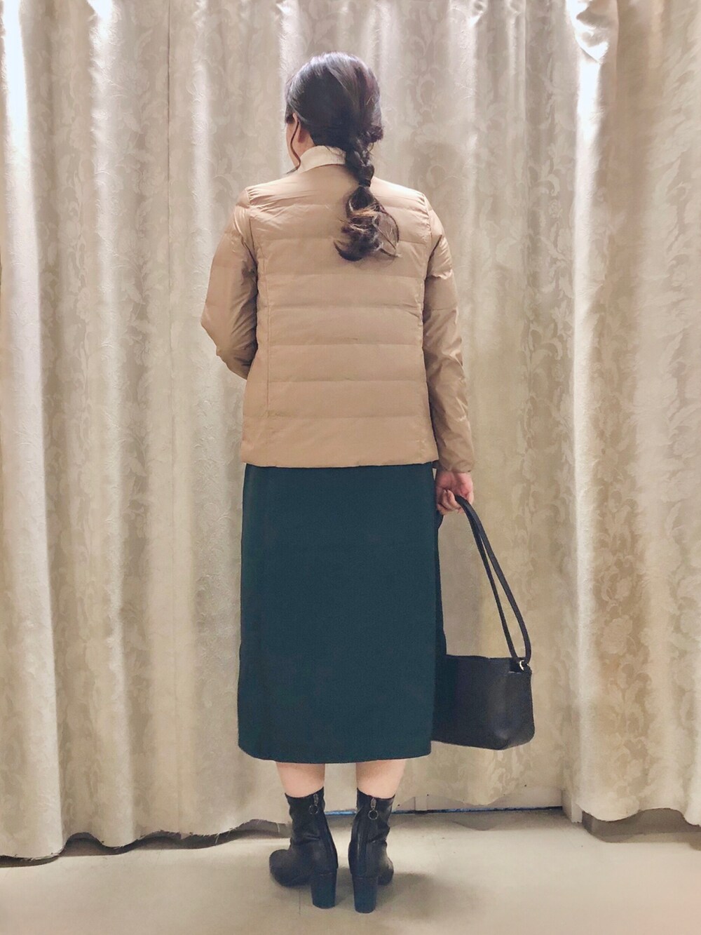 ブラウン系のダウンジャケット/コート、グリーン系のスカート、ホワイト系のニット/セーターを着用したレディースの秋コーディネートの3枚目の写真