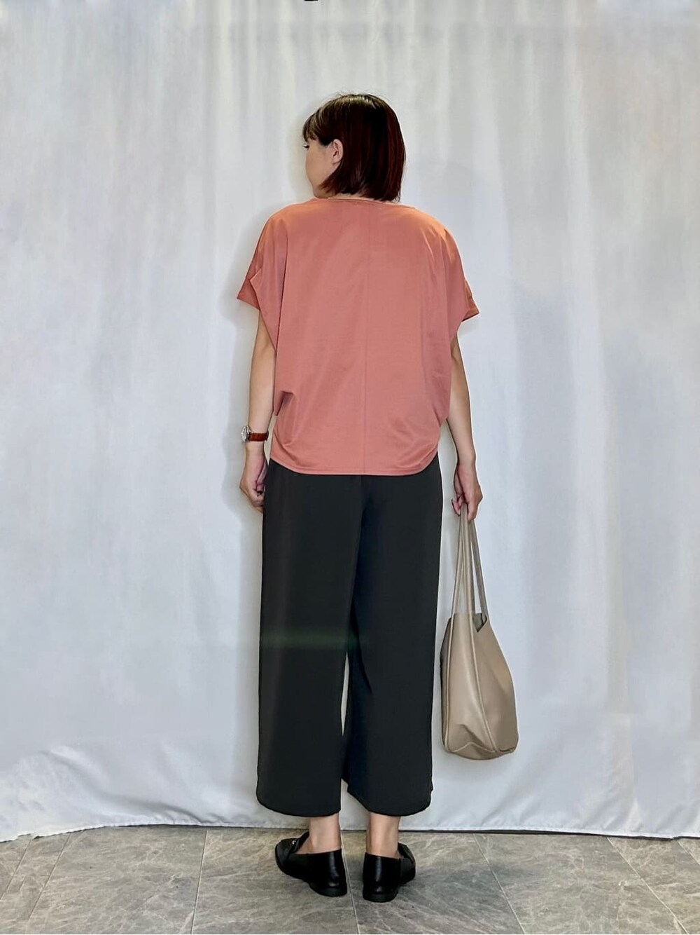 オレンジ系のTシャツ/カットソー、グレー系のその他パンツ、ブラック系のその他シューズを着用したレディースの夏コーディネートの3枚目の写真