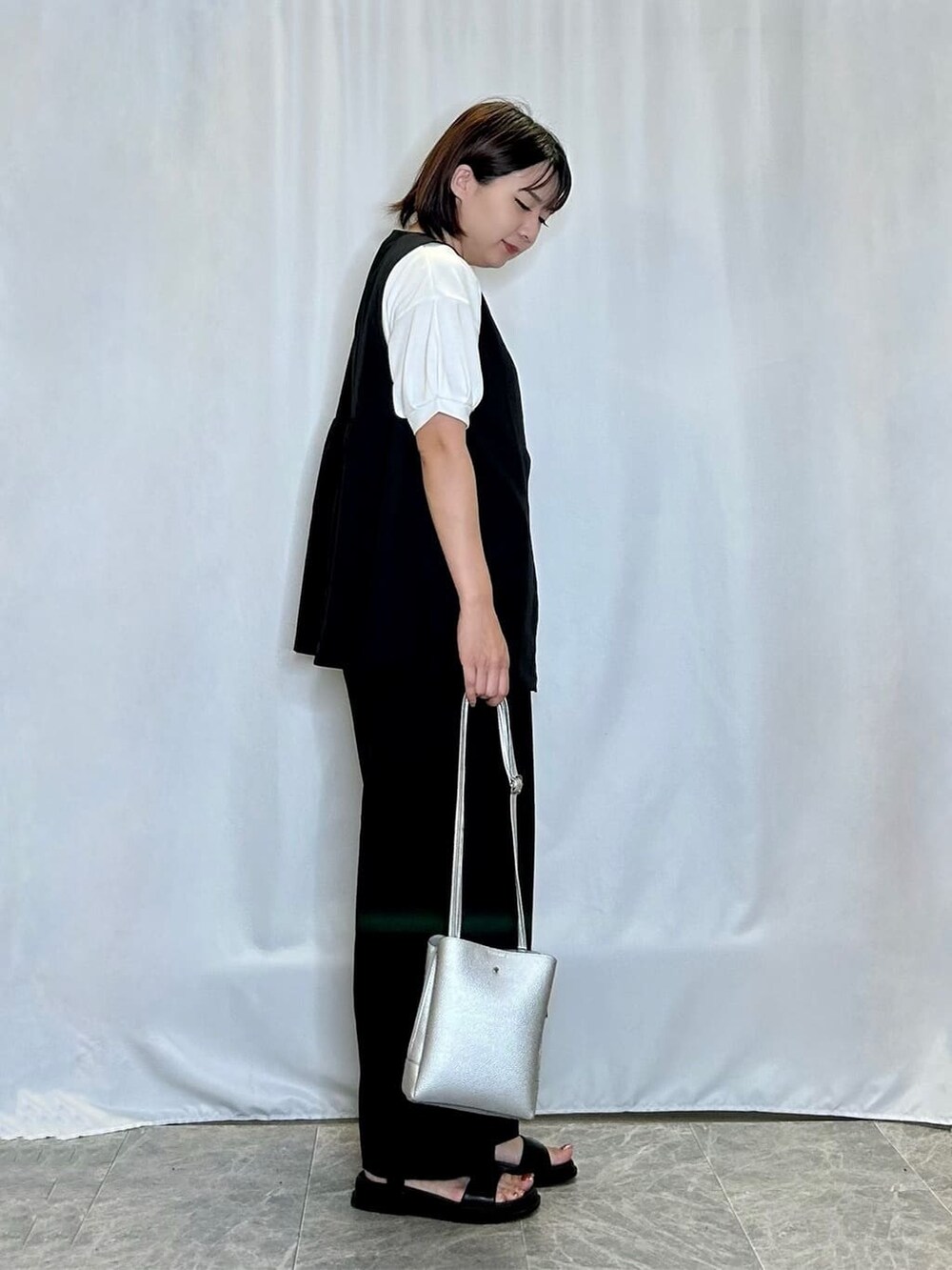 ブラック系のベスト、ホワイト系のTシャツ/カットソー、ブラック系のその他パンツを着用したレディースの夏コーディネートの2枚目の写真