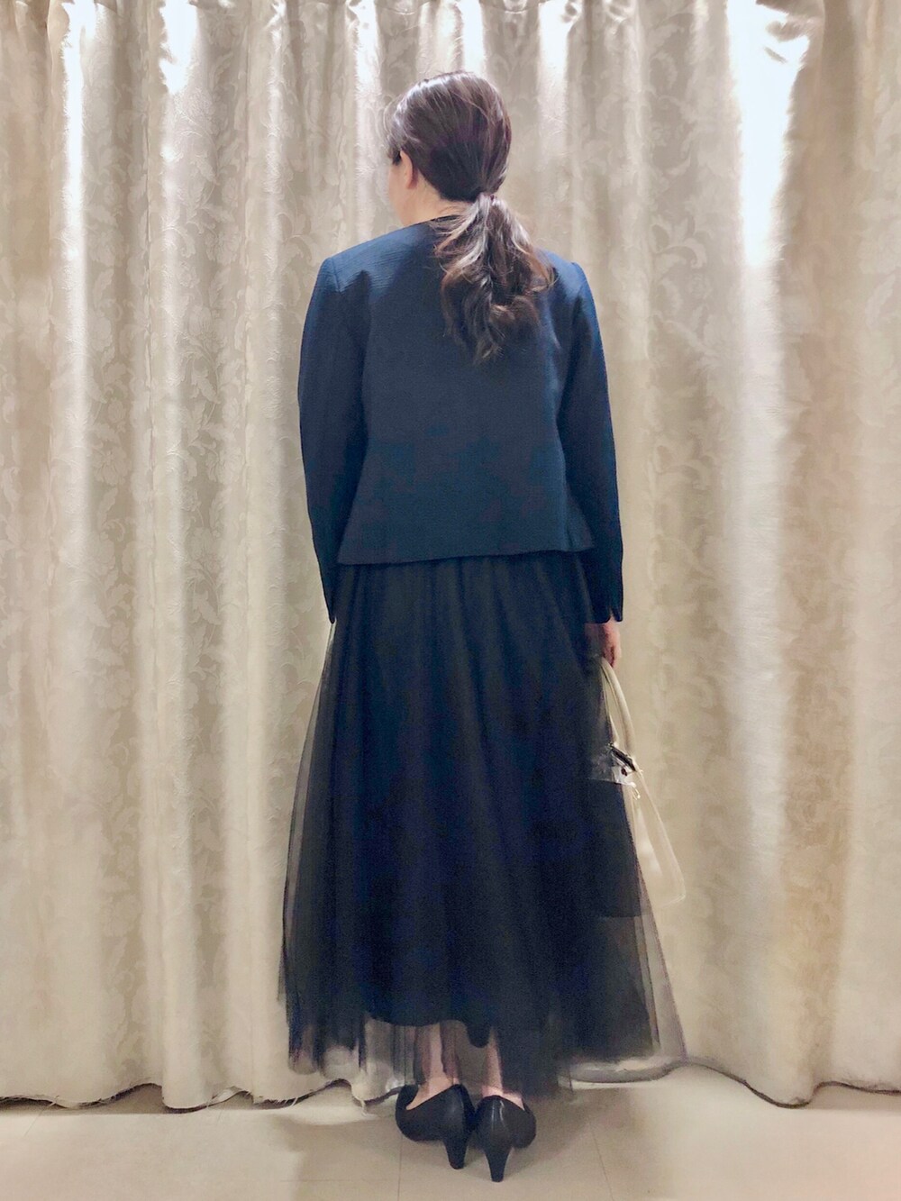 ブルー系のノーカラージャケット、ホワイト系のシャツ/ブラウス、ブラック系のパンプスを着用したレディースの春コーディネートの3枚目の写真