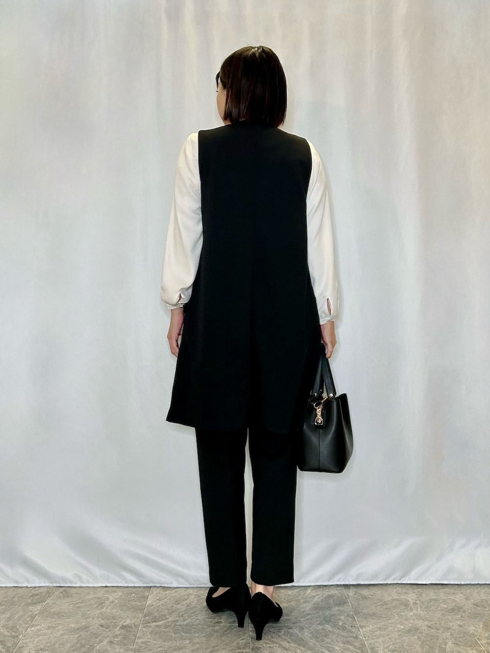 ブラック系のパンプス、ブラック系のその他パンツ、ブラック系のトートバッグを着用したレディースの冬コーディネートの3枚目の写真