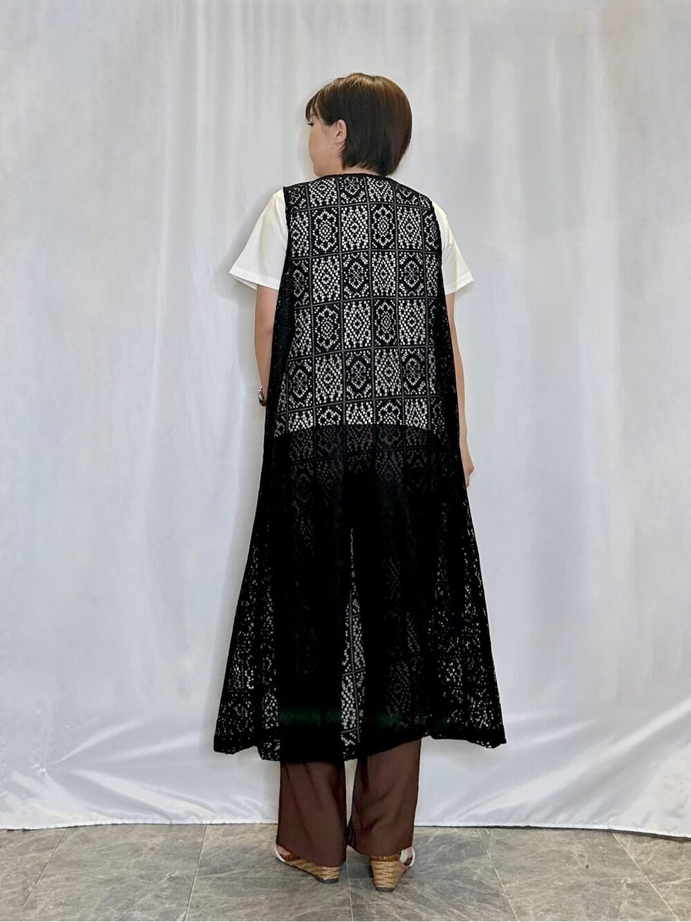 ブラック系のベスト、ホワイト系のTシャツ/カットソー、ブラウン系のその他パンツを着用したレディースの春コーディネートの3枚目の写真