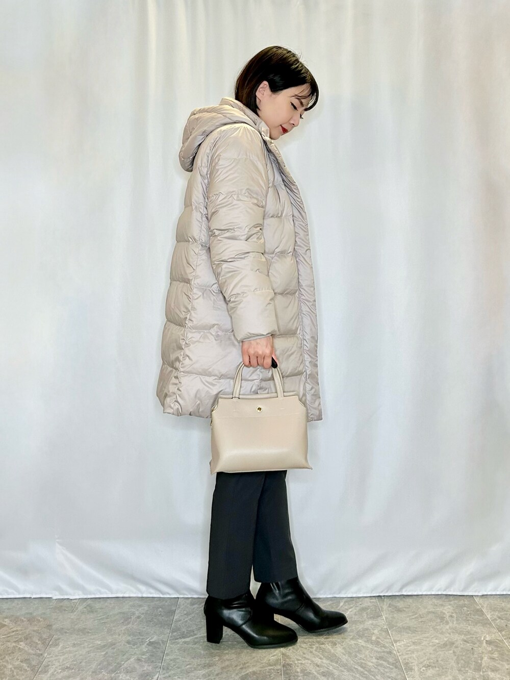 グレー系のその他パンツ、ブラック系のブーツ、グレー系のトートバッグを着用したレディースの冬コーディネートの2枚目の写真