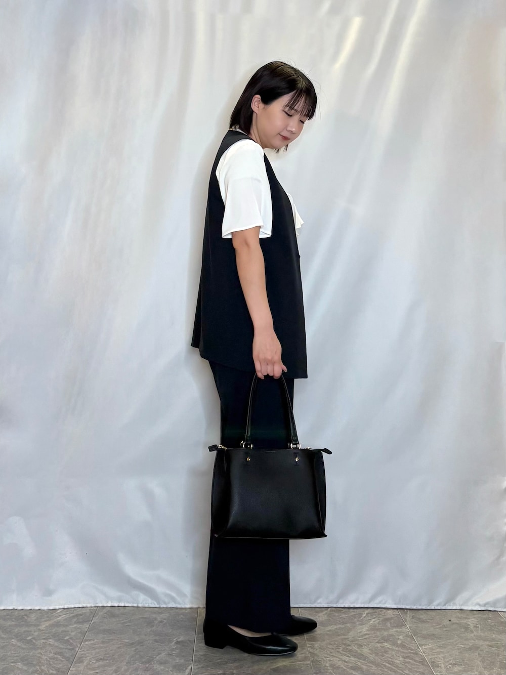 ブラック系のパンプス、ブルー系のその他パンツ、ブルー系のベストを着用したレディースの春コーディネートの2枚目の写真