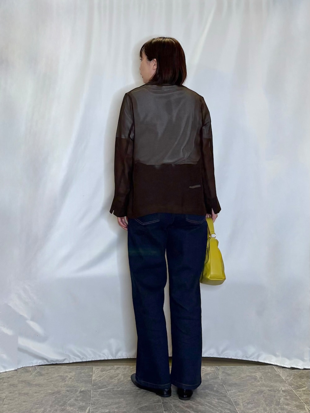 ブラウン系のテーラードジャケット、ホワイト系のTシャツ/カットソー、ブルー系のデニムパンツを着用したレディースの秋コーディネートの3枚目の写真
