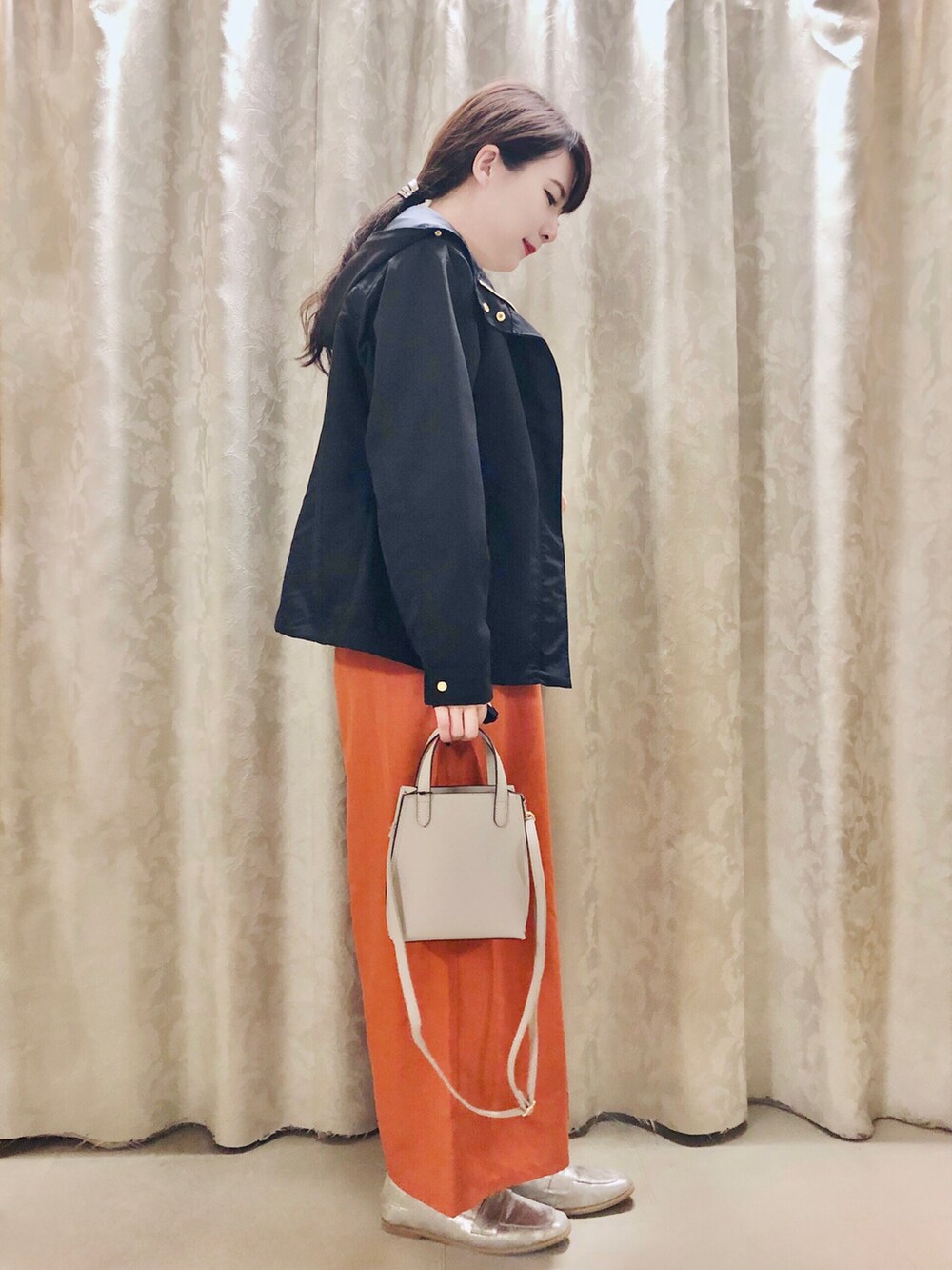 ブルー系のブルゾン、オレンジ系のその他パンツ、グレー系のショルダーバッグを着用したレディースの春コーディネートの2枚目の写真