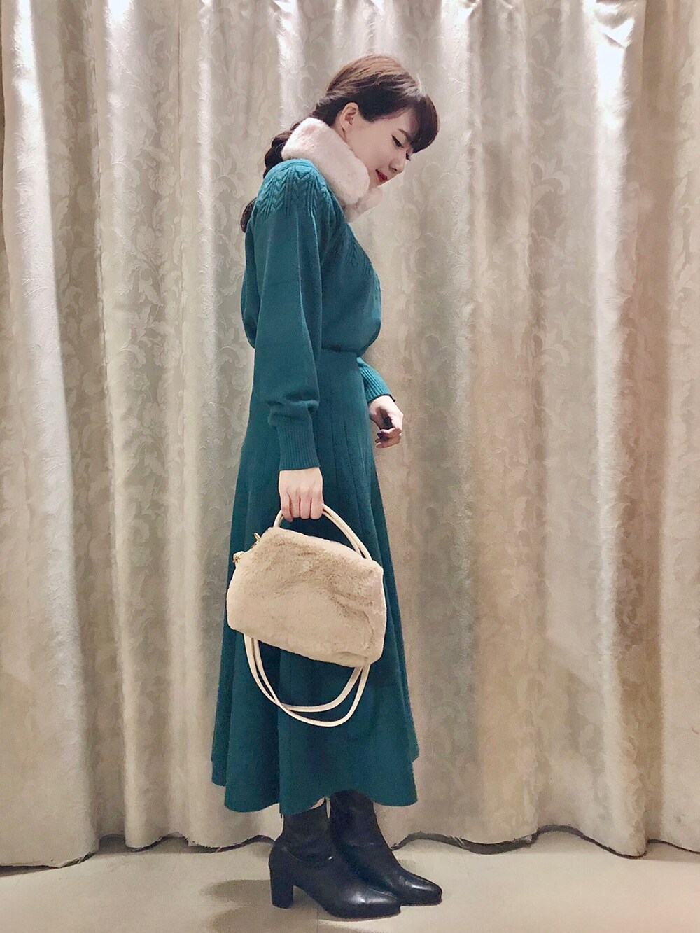 ホワイト系のショルダーバッグ、ブラック系のブーツ、グリーン系のニット/セーターを着用したレディースの秋コーディネートの2枚目の写真