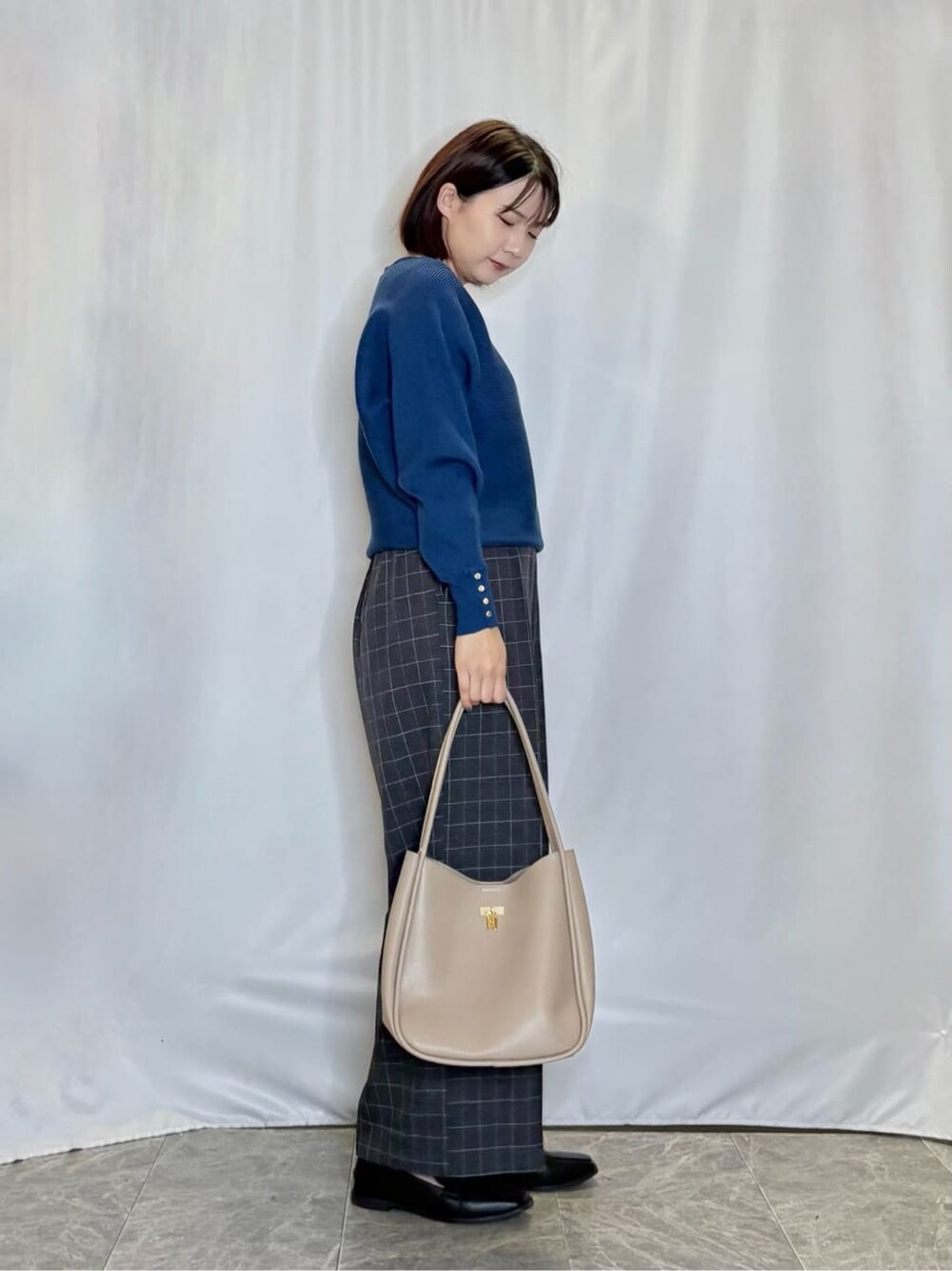 ブルー系のニット/セーター、グレー系のその他パンツ、ブラック系のその他シューズを着用したレディースの秋コーディネートの2枚目の写真