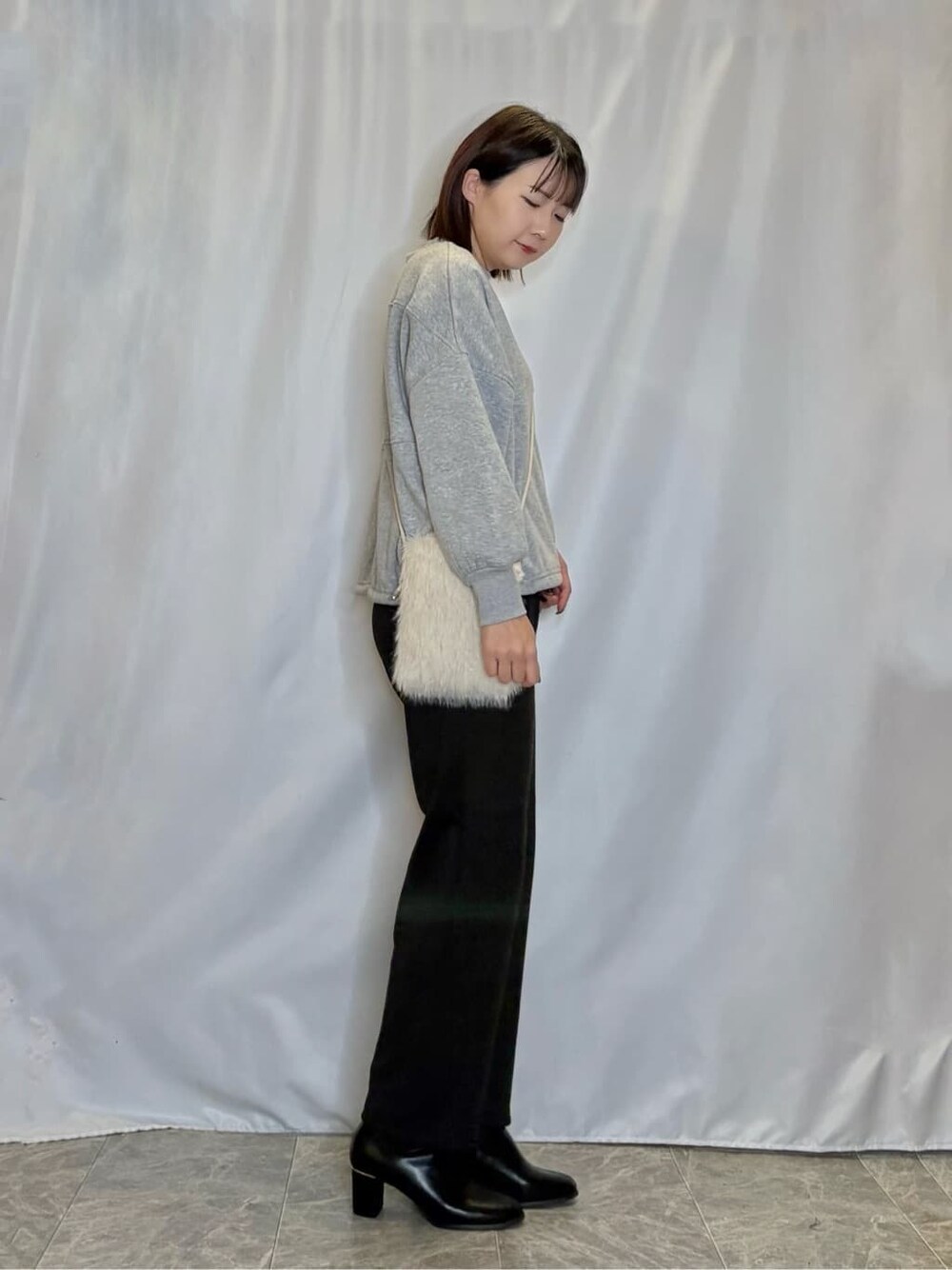 グレー系のスウェット、ブラック系のその他パンツ、ブラック系のブーツを着用したレディースの秋コーディネートの2枚目の写真