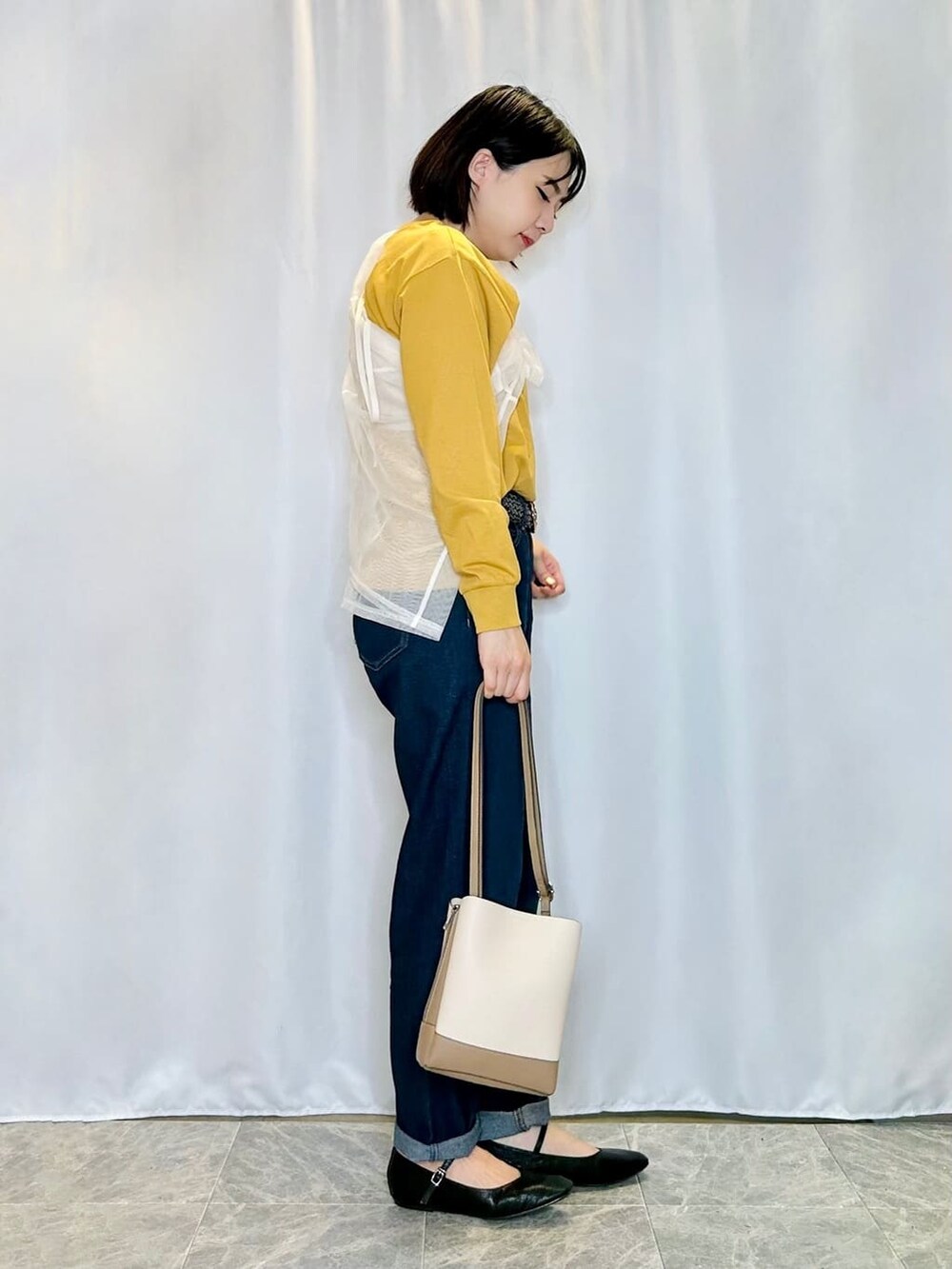 ブルー系のデニムパンツを着用したレディースの秋コーディネートの2枚目の写真