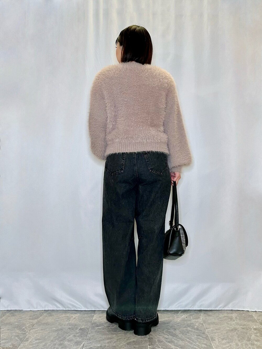 ブラック系のブーツ、ブラック系のその他パンツ、ブラウン系のニット/セーターを着用したレディースの冬コーディネートの3枚目の写真