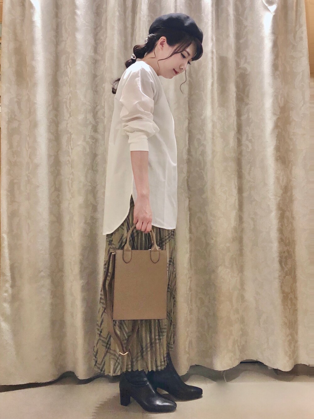 ホワイト系のシャツ/ブラウス、ベージュ系のスカート、ブラック系のブーツを着用したレディースの秋コーディネートの2枚目の写真