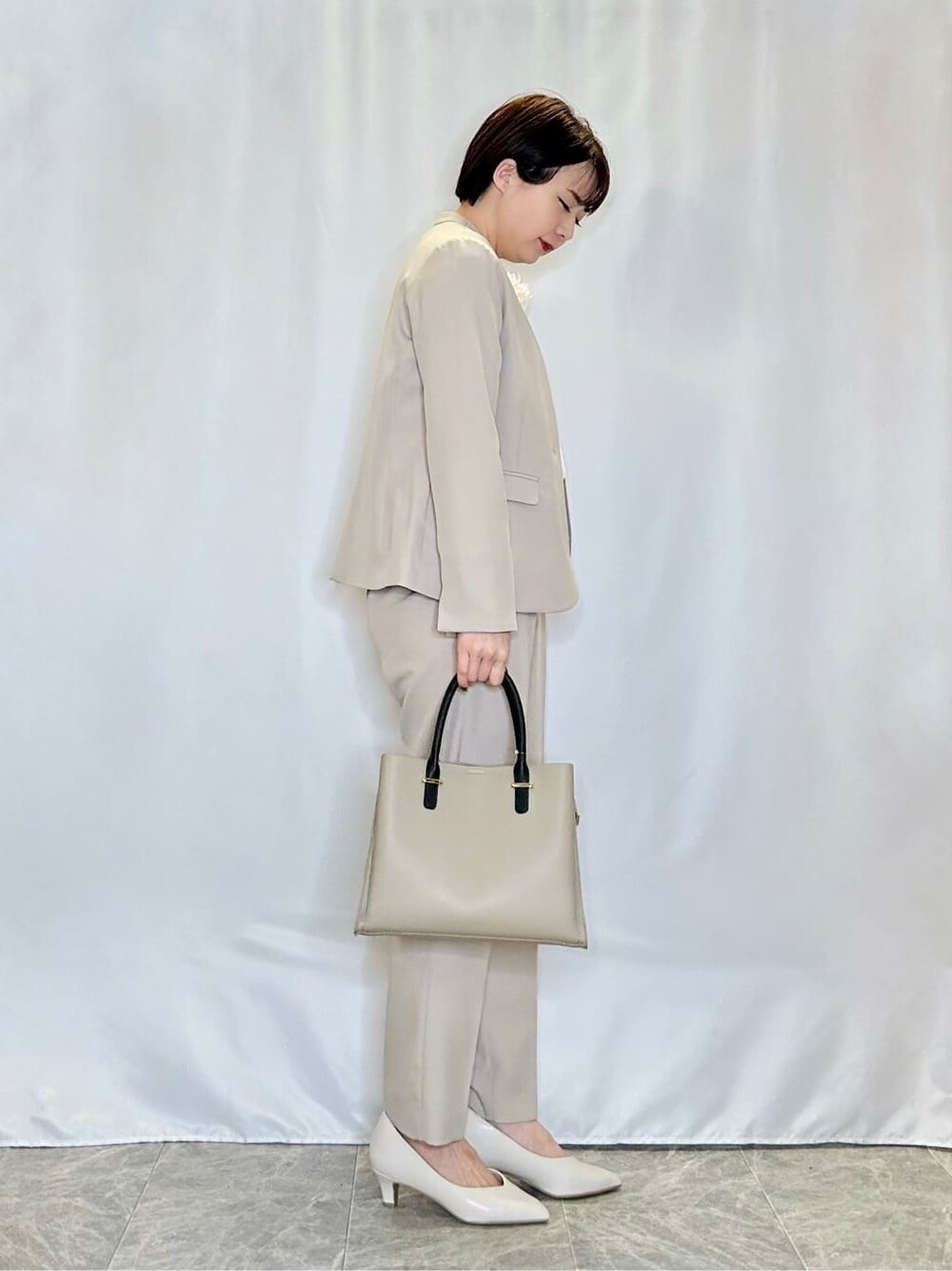 ベージュ系のノーカラージャケット、ホワイト系のシャツ/ブラウス、ベージュ系のその他パンツを着用したレディースの春コーディネートの2枚目の写真