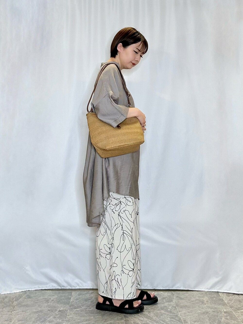 ブラック系のサンダル、ホワイト系のその他パンツ、ベージュ系のショルダーバッグを着用したレディースの春コーディネートの2枚目の写真