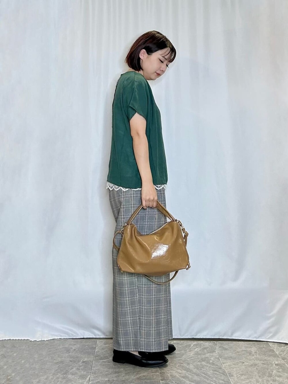 グリーン系のTシャツ/カットソー、グレー系のその他パンツ、ブラック系のその他シューズを着用したレディースの秋コーディネートの2枚目の写真