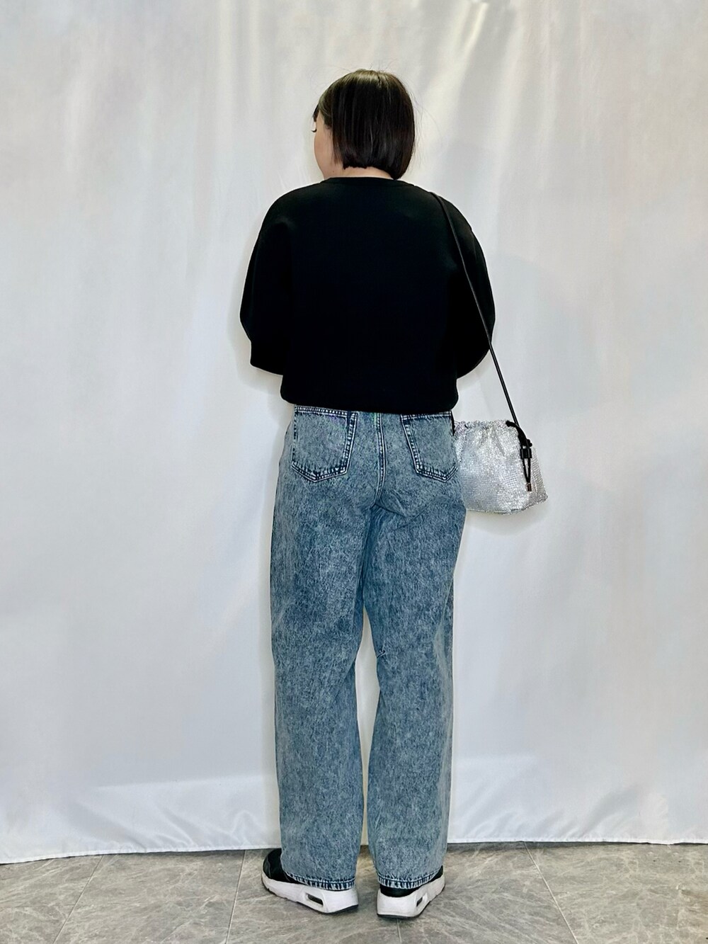 ブルー系のその他パンツ、シルバー系のショルダーバッグ、ブラック系のニット/セーターを着用したレディースの冬コーディネートの3枚目の写真