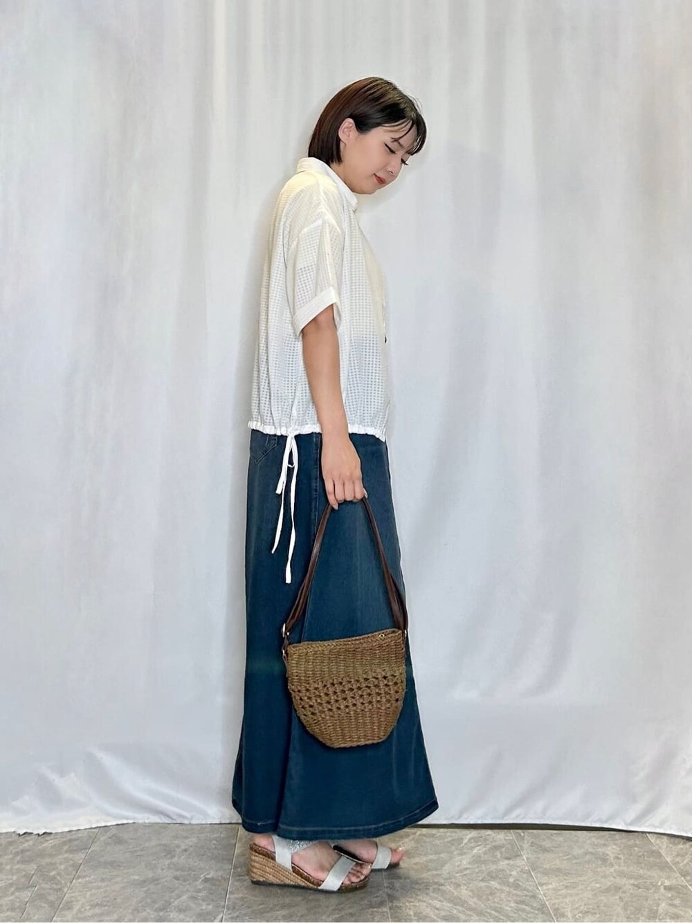 ホワイト系のシャツ/ブラウス、イエロー系のTシャツ/カットソー、ブルー系のデニムスカートを着用したレディースの夏コーディネートの2枚目の写真