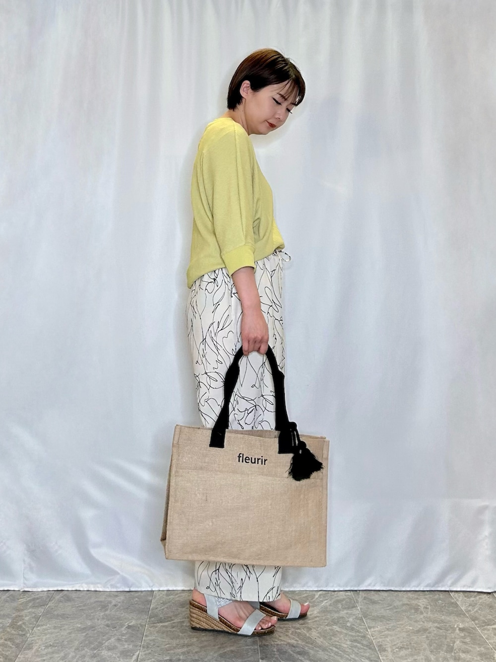 イエロー系のTシャツ/カットソー、シルバー系のサンダル、ホワイト系のその他パンツを着用したレディースの春コーディネートの2枚目の写真