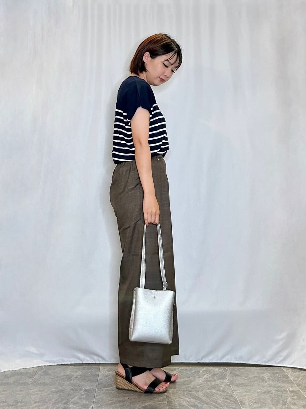 ブルー系のニット/セーター、ブラウン系のその他パンツ、ブラック系のサンダルを着用したレディースの夏コーディネートの2枚目の写真
