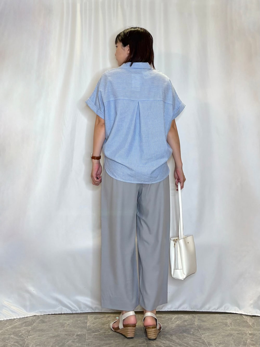 ブルー系のシャツ/ブラウス、グレー系のその他パンツ、ホワイト系のサンダルを着用したレディースの夏コーディネートの5枚目の写真